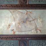 Al centro del soffitto cornici lignee e riquadri con cigni e decori vegetali delimitano la splendida tela ottocentesca del pittore barese Raffaele Armenise... 